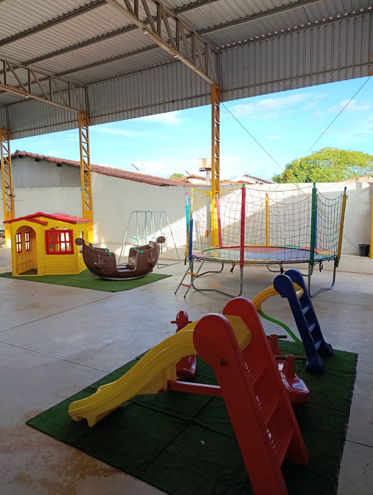 Área coberta com casinha, escorregador, gangorra e cama elástica